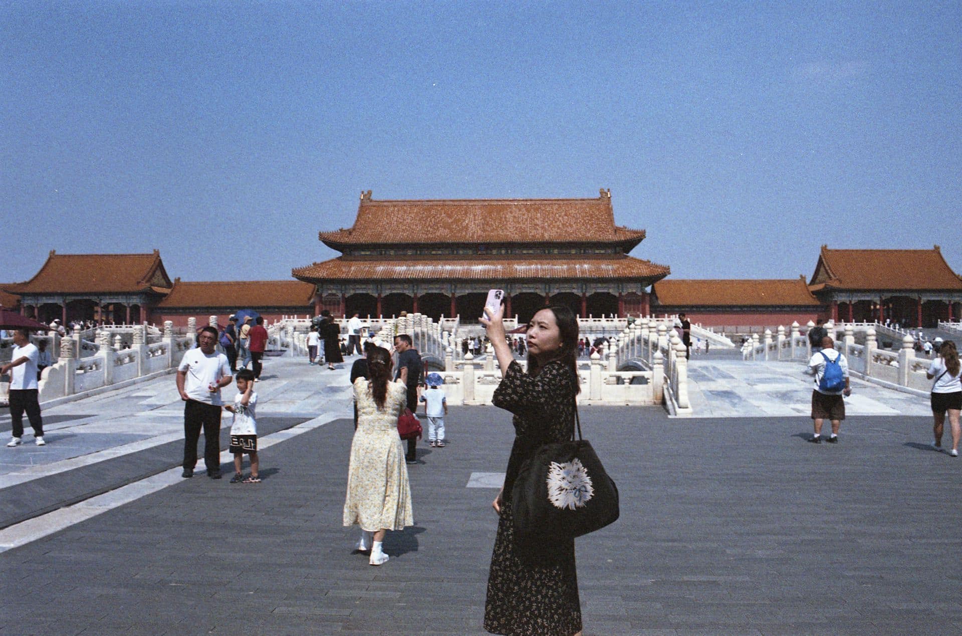 Young woman taking photos at Forbidden City Beijing China 35mm film photography