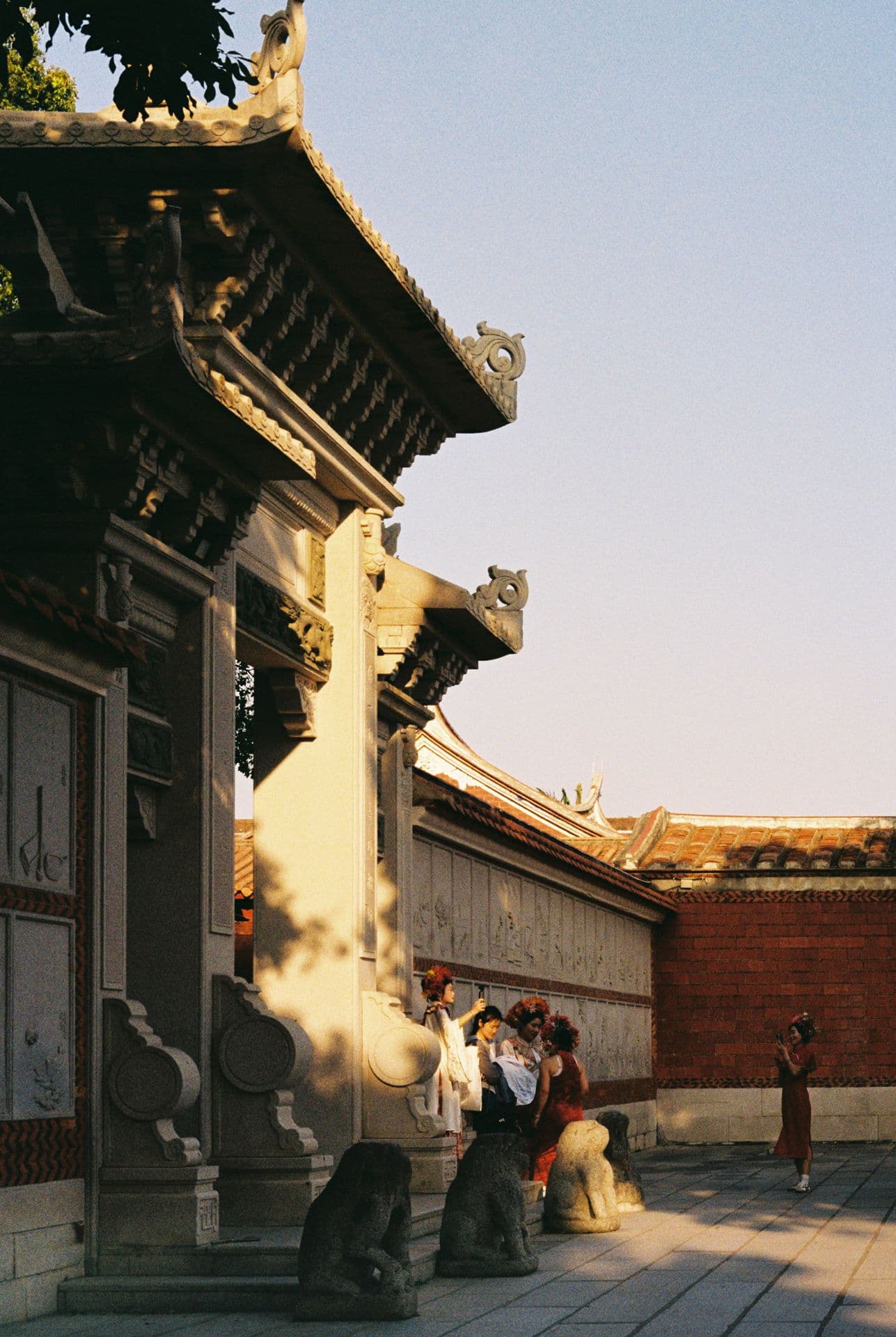 Chinese girls in traditional clothes posing for photos in front of a big gate in Quanzhou 35mm film photography