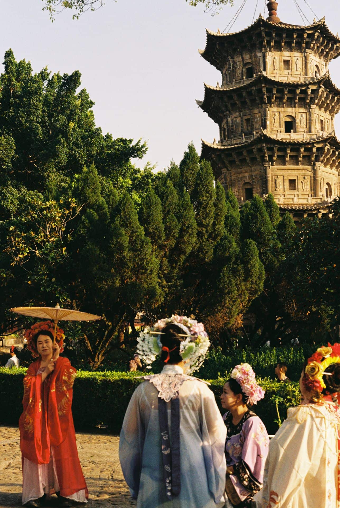 Chineze women in traditional clothes posing for photos in front of a pagoda 35mm film photography