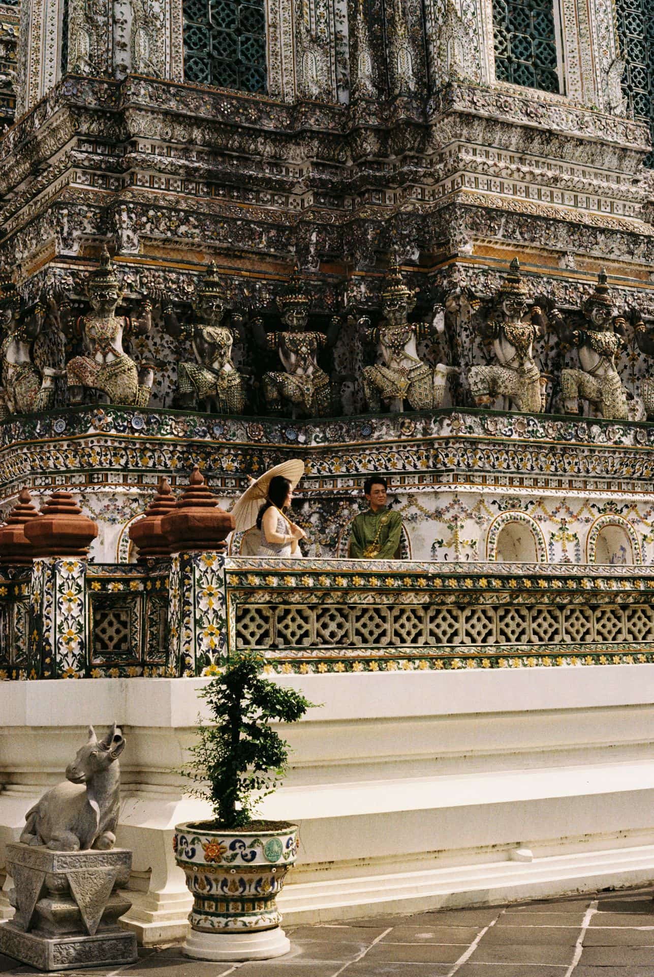 A couple posing for photos dressed in traditional Thai clothes in Wat Arun in Bangkok 35mm film photography